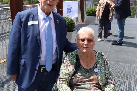 Eine Frau im Rollstuhl und ein Mann daneben.