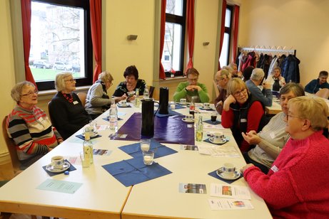 Jahreshauptversammlung, mehrere Personen sitzen an Tischen zusammen.