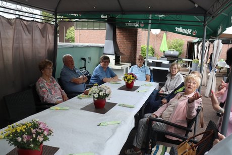 Grillnachmittag vom VdK Ortsverband Borbeck gemeinsam mit dem Ortsverband Altendorf. Teilnehmer sitzen an einem langen Tisch unter einem Pavillon.