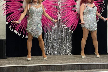 Show Künstler auf der Bühne in Gewänder( silber und lila Pfau auf den Rücken)