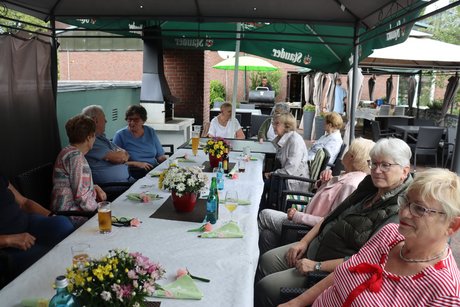Grillnachmittag vom VdK Ortsverband Borbeck gemeinsam mit dem Ortsverband Altendorf. Teilnehmer sitzen an einem langen Tisch unter einem Pavillon.