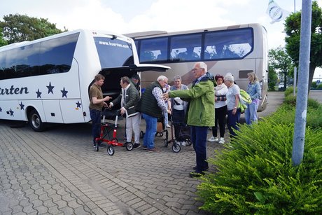 Abfahrt zum Dümmer See Menschen stehen vor einem Buss bereit zur Abfahrt