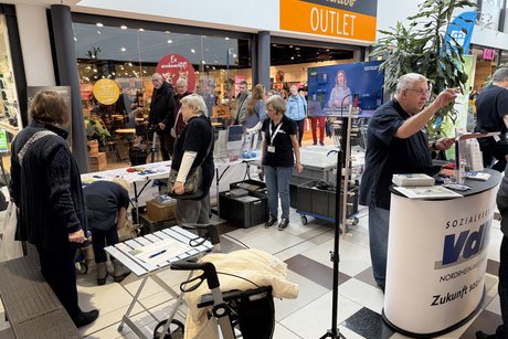 Mehrere Menschen stehen an einem VdK Info-Stand.