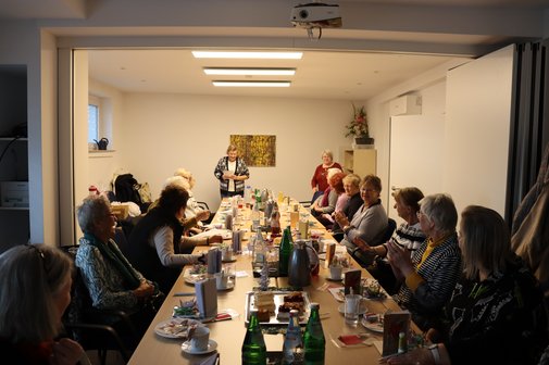 Vertreterinnen der Frauen sitzen an einem langen Tisch zusammen.
