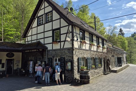 Mehrere Personen stehen vor einem Haus.