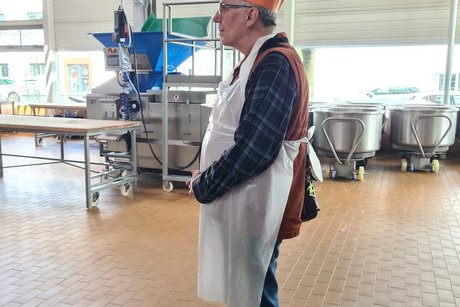 Besuch bei Bäckerei Peter. Ein Mitglied mit Schürze und Bäckerhaube bekleidet.