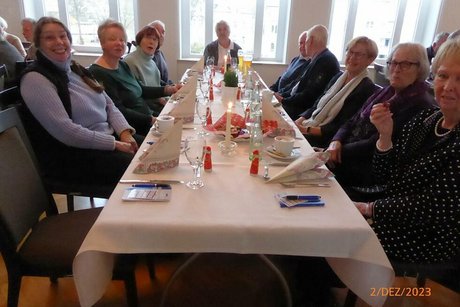 Eine Gruppe Menschen sitzt gemeinsam an einem Tisch.