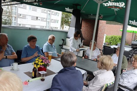 Grillnachmittag vom VdK Ortsverband Borbeck gemeinsam mit dem Ortsverband Altendorf. Teilnehmer sitzen an einem langen Tisch unter einem Pavillon.