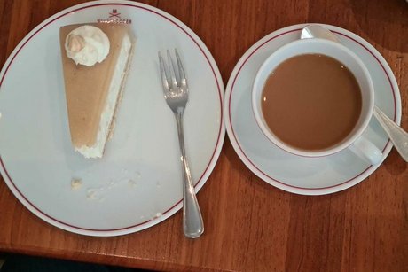Von oben fotografiertes Stück Marzipantorte und eine Tasse Kaffee.