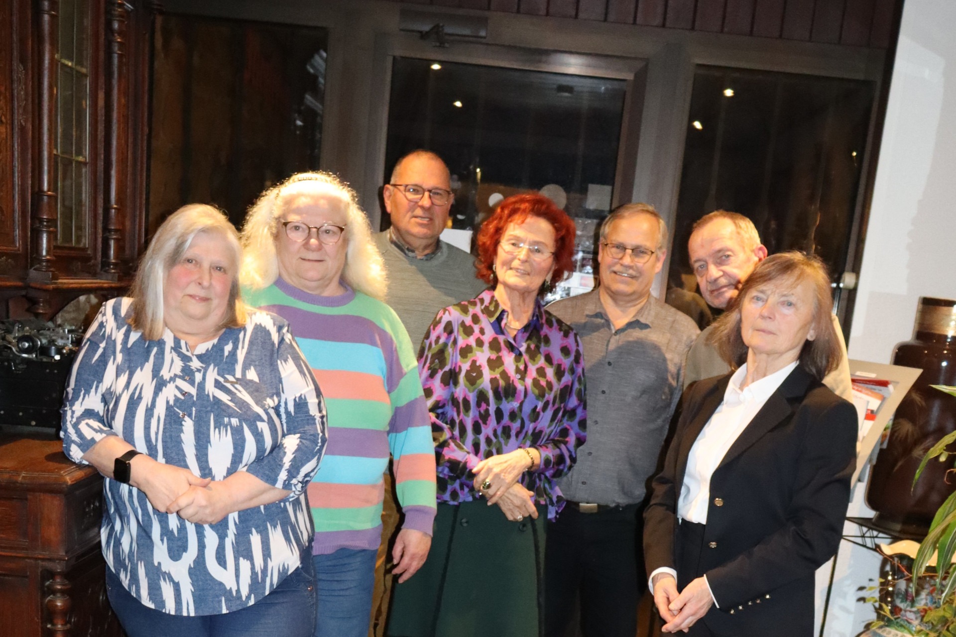 Sieben Personen stehen zusammen für ein Gruppenfoto.