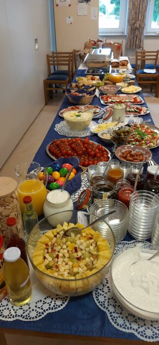 Buffettisch mit Hefezopf, Obstsalat, Cocktailtomaten, Rührei, Würstchen, Käsecreme, Aufschnitt, O-Saft, Marktkäse, Croissants, Saft und und und