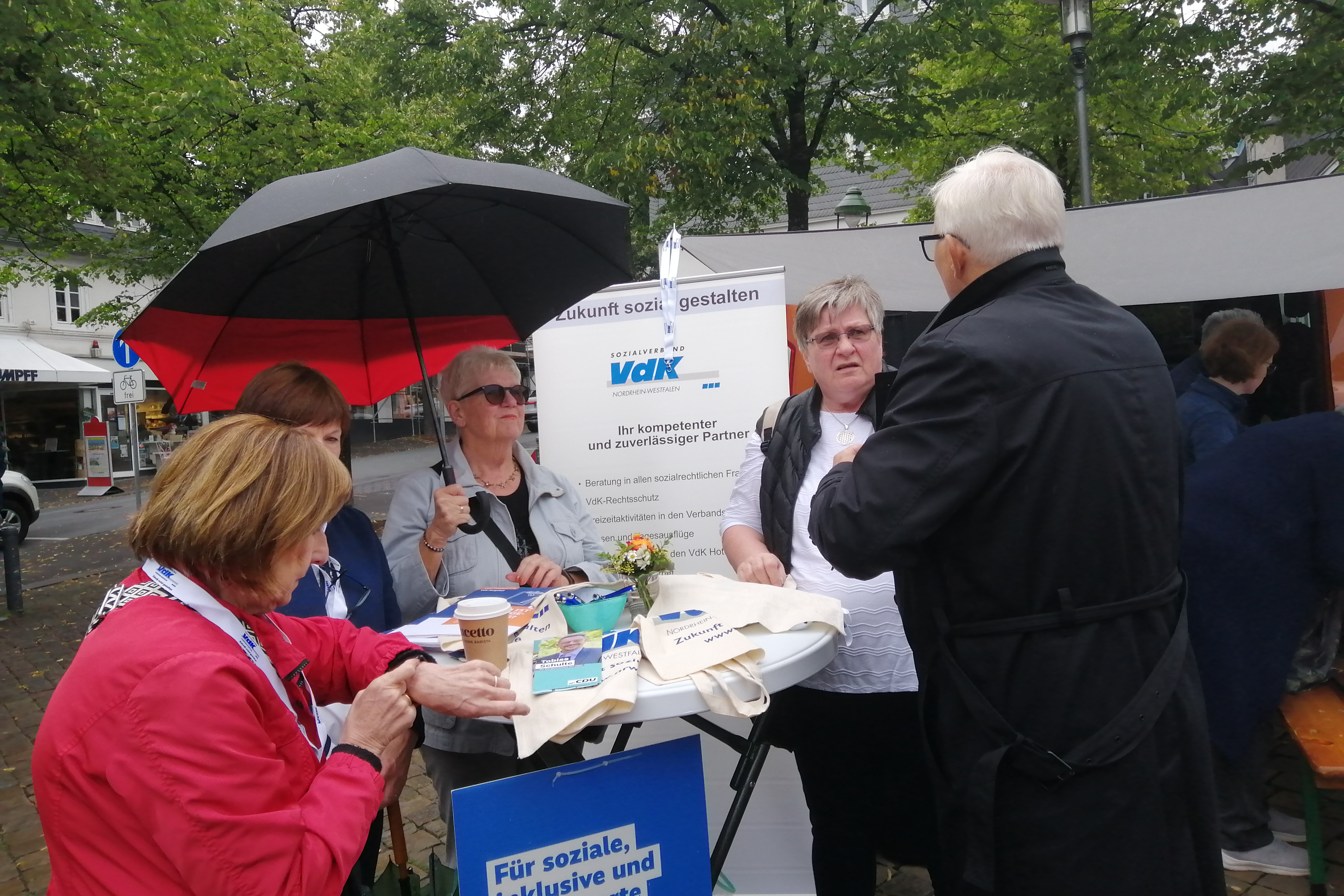 Auf dem Foto ist der Stand des VdK Ortsverband Olpe auf dem Marktplatz in Olpe zu sehen. Die Ortsvorsitzende Mariele Dahm ist im Gespräch mit dem Bürgermeisterkandidaten Dr. Norbert Seyffert.