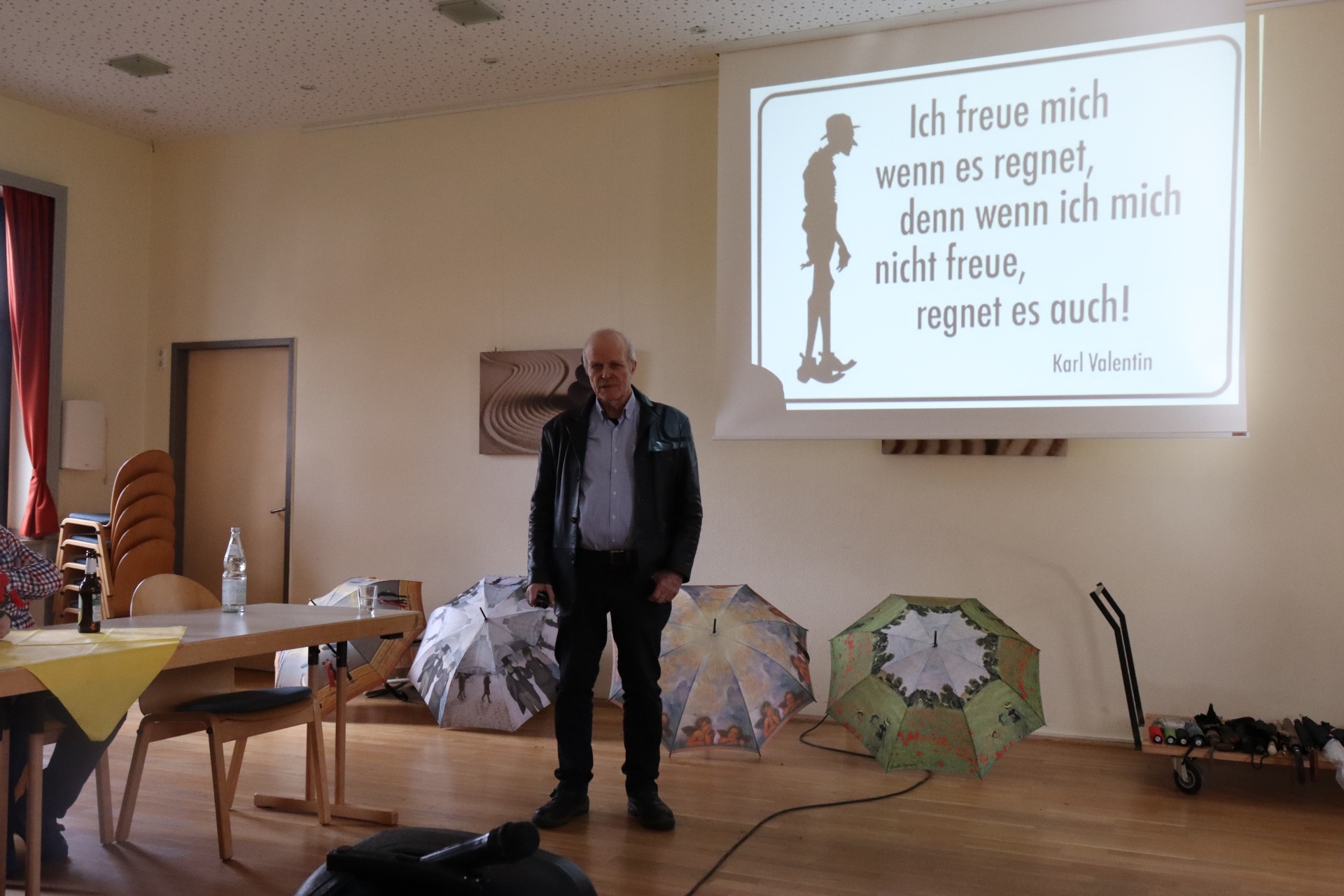 Ein Mann steht vor einer Leinwand und h&auml;lt einen Vortrag.