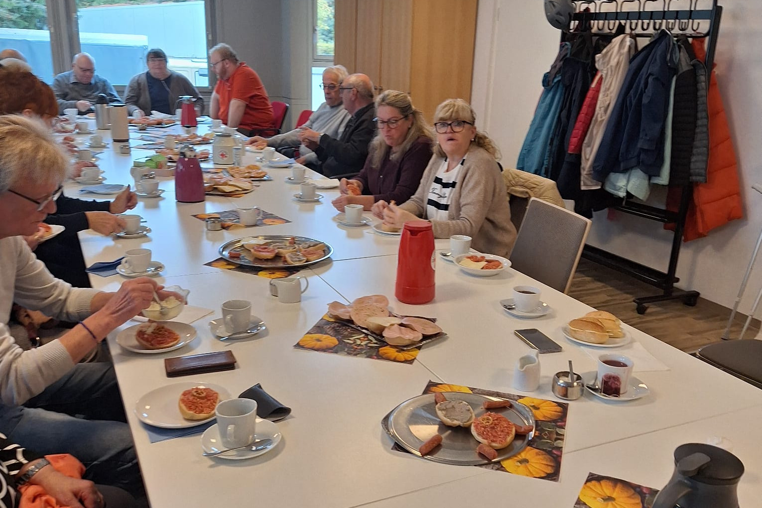 Menschengruppe am Tisch zum Fr&uuml;hst&uuml;ckstreff