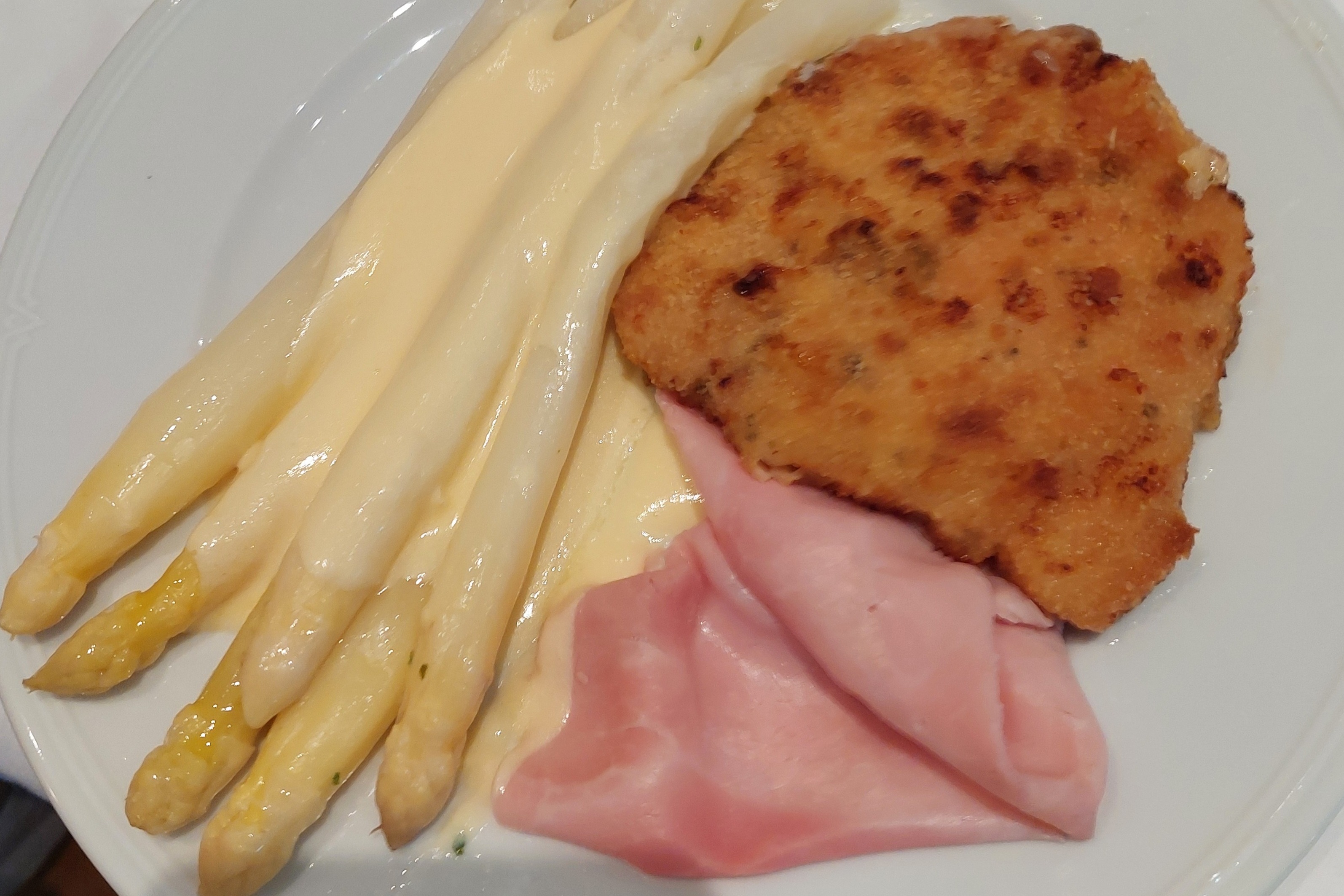 Teller mit Spargel, Schinken, Schnitzel und einer leckeren Soße