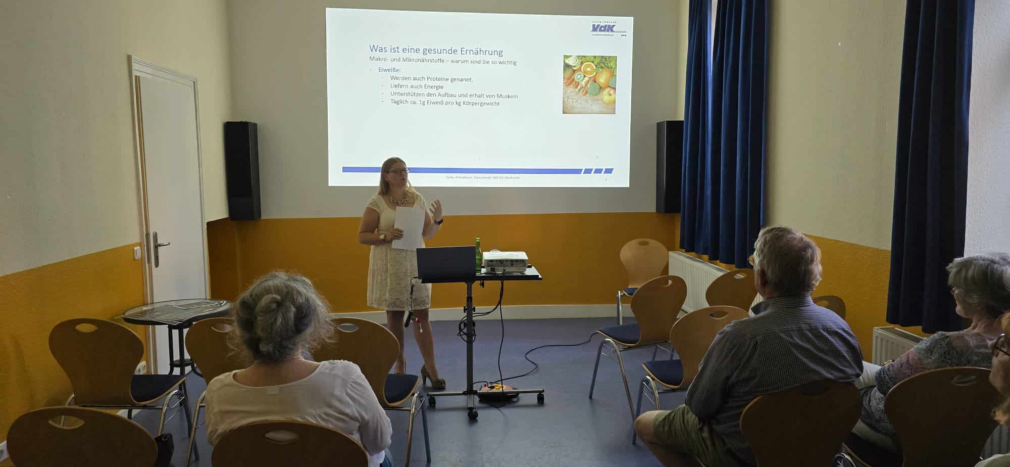 Themenabend Gesunde Ernährung im Alter 2024 Menschen auf Stühle die der Vortragenden im Vordergrund lauschen