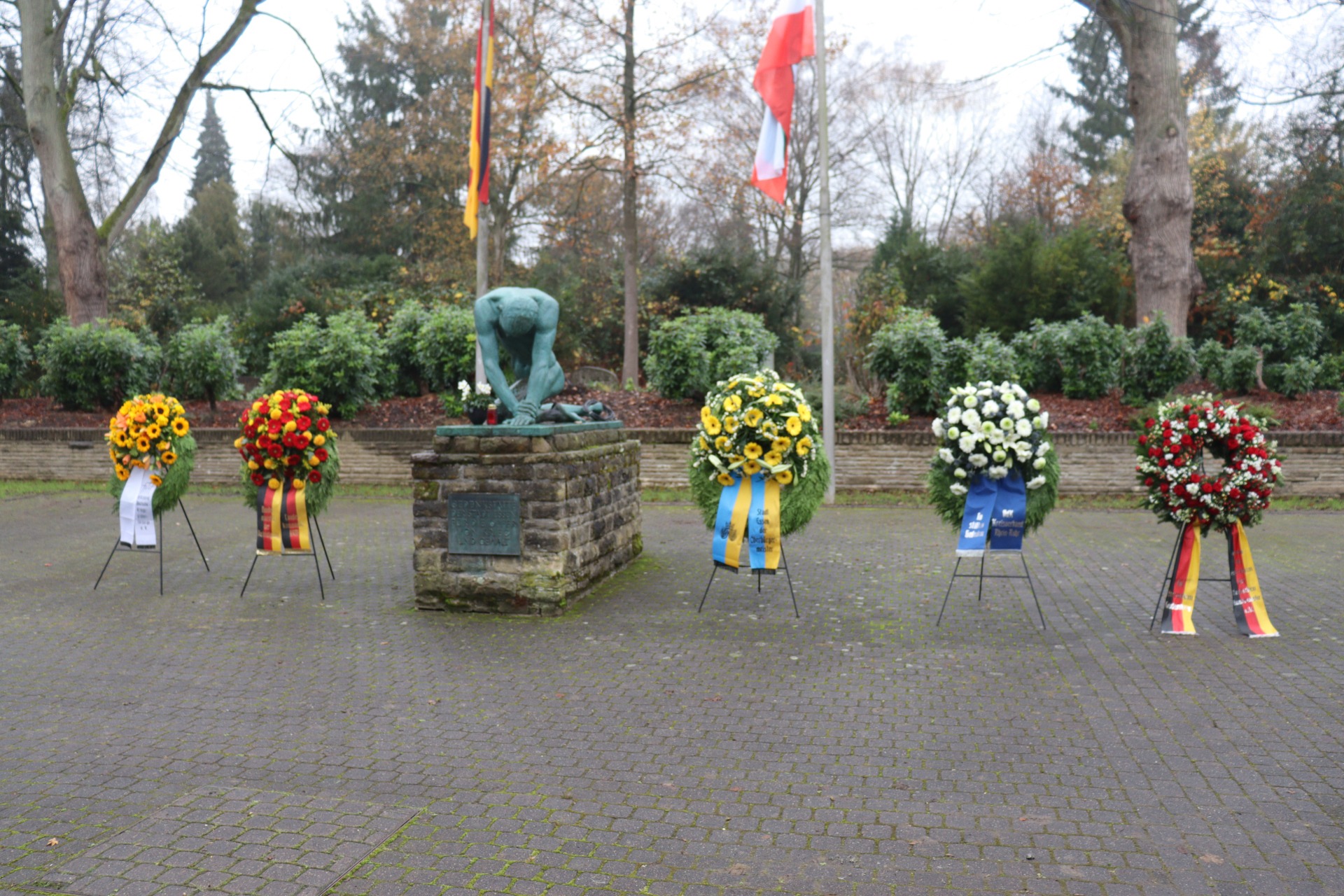 Mehrere Kränze sind vor dem Ehrenmal aufgestellt.