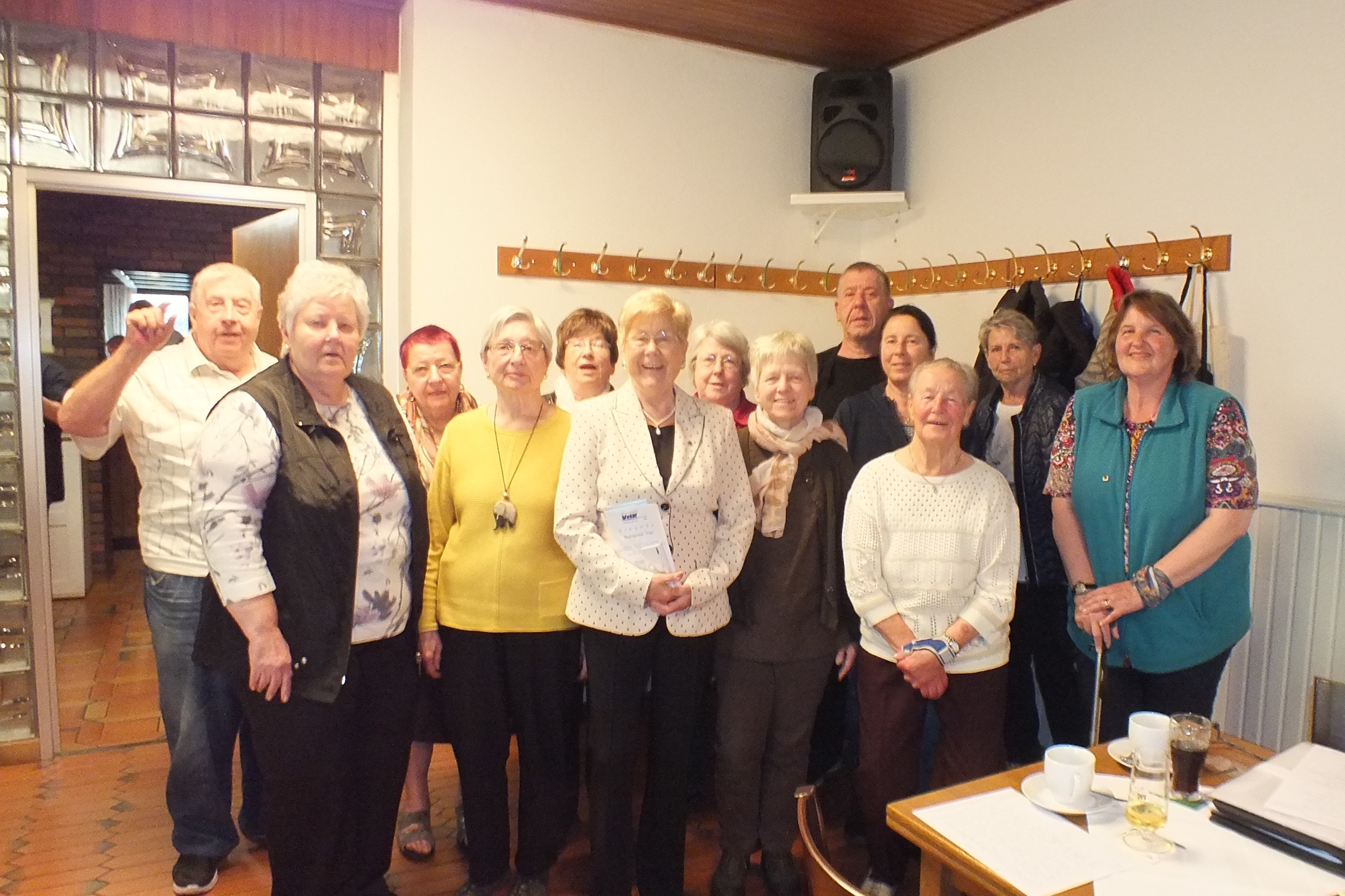 13 Personen stehen zusammen für ein Gruppenbild.