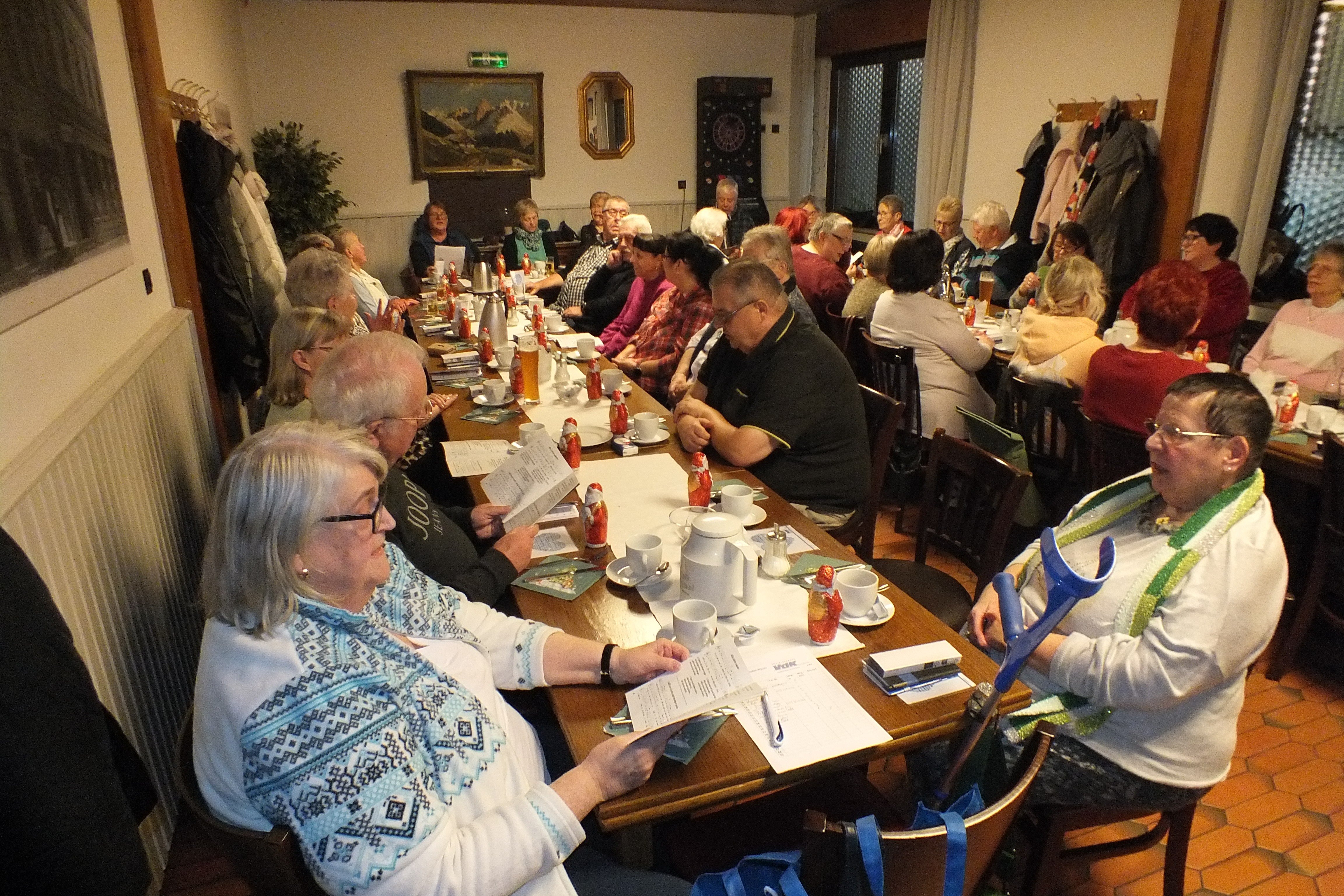 Mehrere Menschen sitzen an festlich gedeckten Tischen.