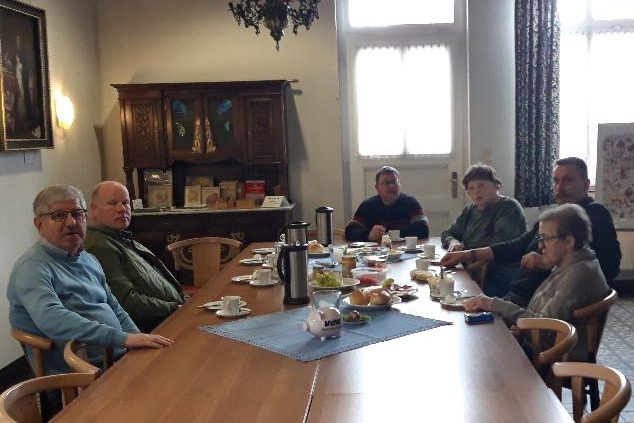 Menschen sitzen an einem Tisch und frühstücken