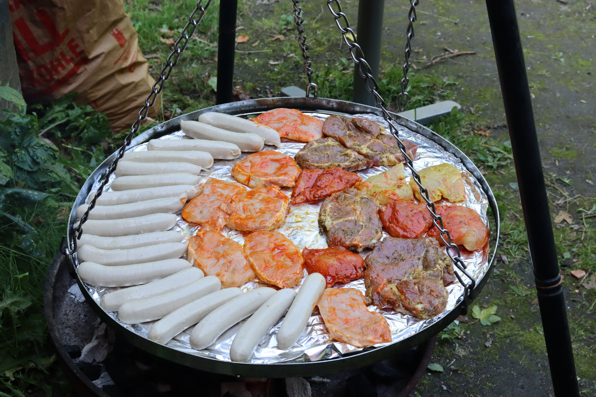 Grillwurst und Fleisch auf einem Grill.