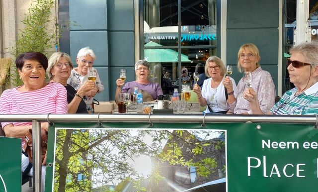 Frauen sitzen gemeinsam an einem Tisch auf der Außenterrasse eines Restaurants