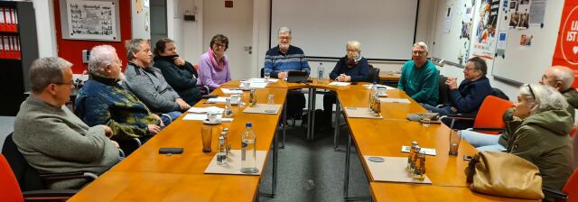 Menschen sitzen gemeinsam an einem Konferenztisch