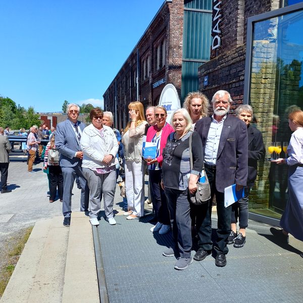 Zehn Menschen stehen vor dem Eingang zur Turbinenhalle Bochum