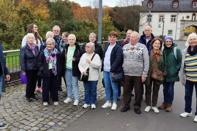 Gruppenfoto Tagesreise Eine Gruppe von Menschen, überwiegend Frauen gemischtes Alter vor historischem Gebäude