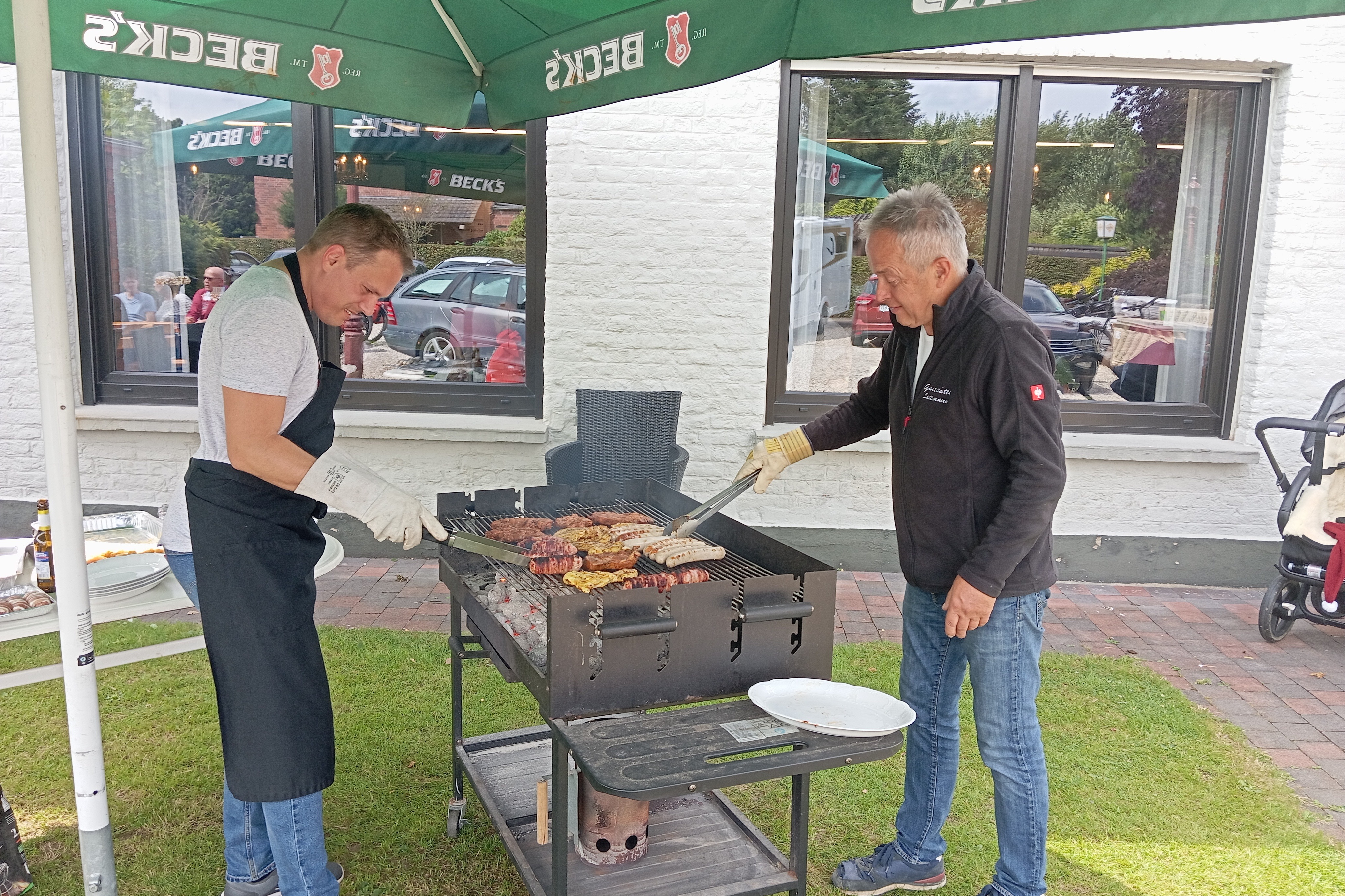 Sommerfest 2025 Vereinswirt Rudi Verhülsdonk (rechts im Bild) sorgt mit seinem Lettmann-Team am 5. Juli dafür, dass den Mitgliedern und Freunden des Ortsverbands Uedem heißes vom Grill und knackige Salate zu kühlen und warmen Getränken serviert werden..