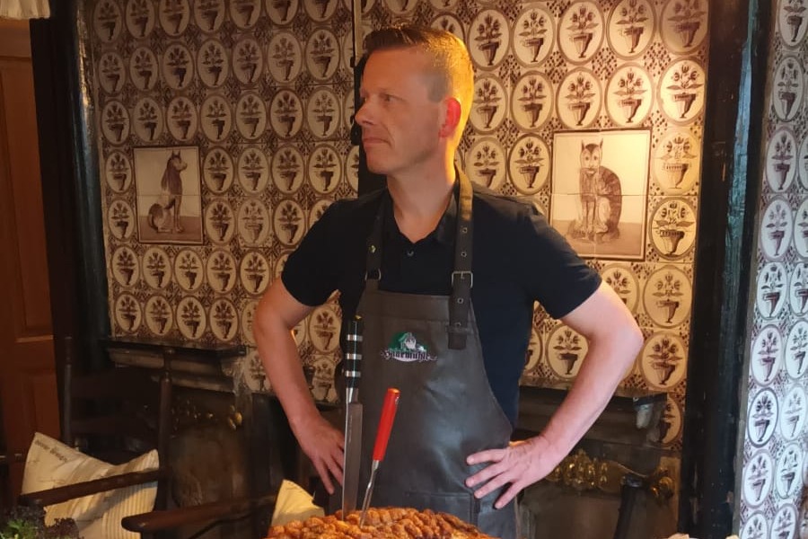 Der Koch steht am Buffet um die G&auml;ste zu bedienen.