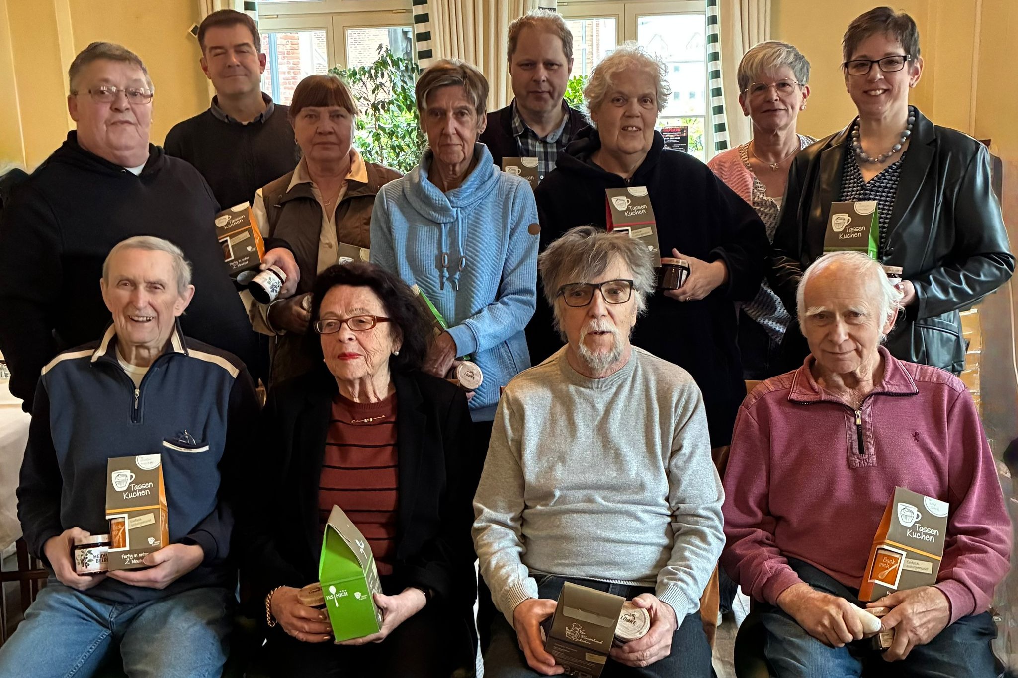 Personen stehen oder sitzen f&uuml;r Gruppenfoto