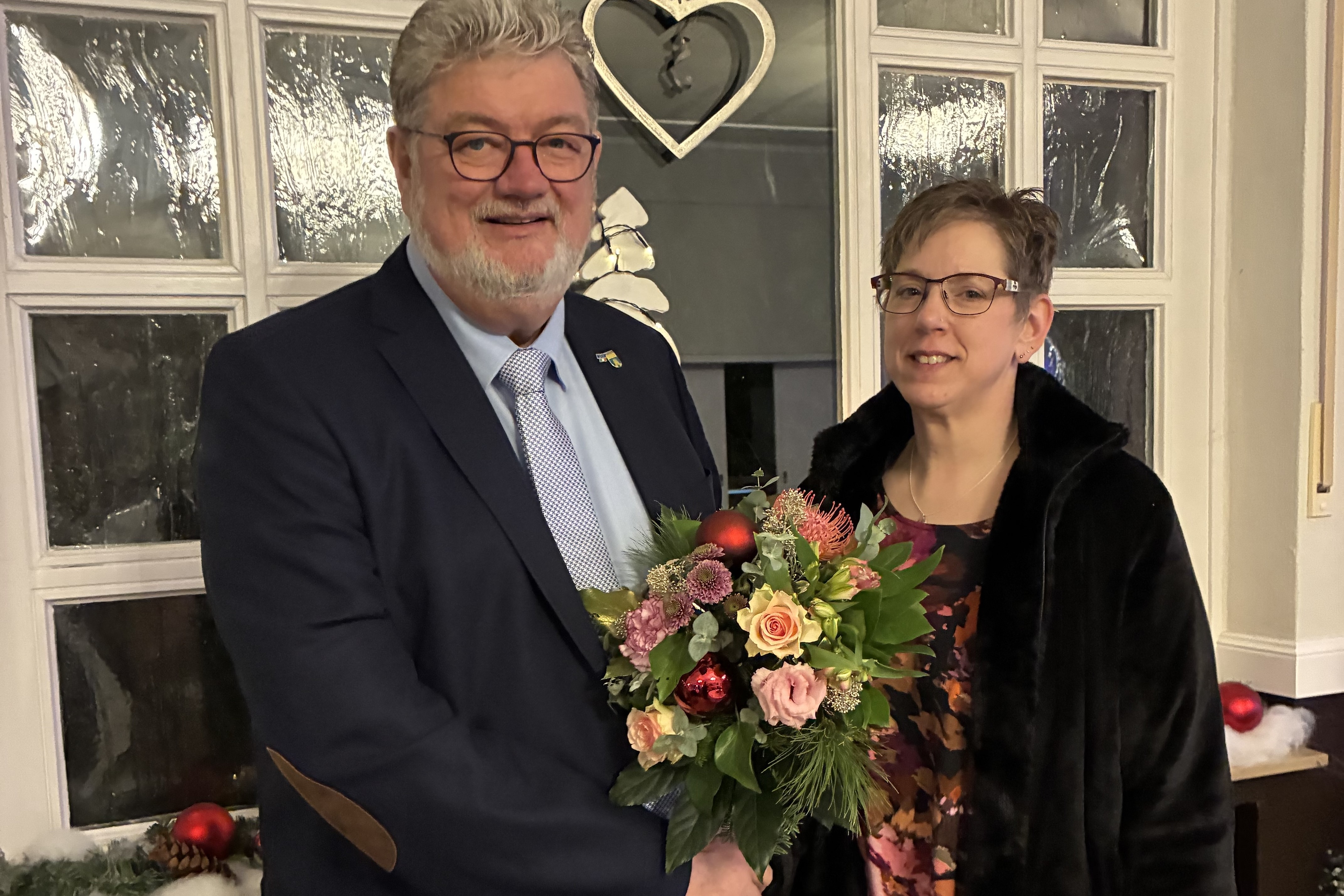 Ein Mann h&auml;lt einen Blumenstrau&szlig; und gratuliert einer Frau