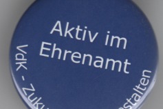 Das Bild zeigt einen Button mit wei&szlig;er Schrift aktiv im Ehrenamt auf blauen Grund